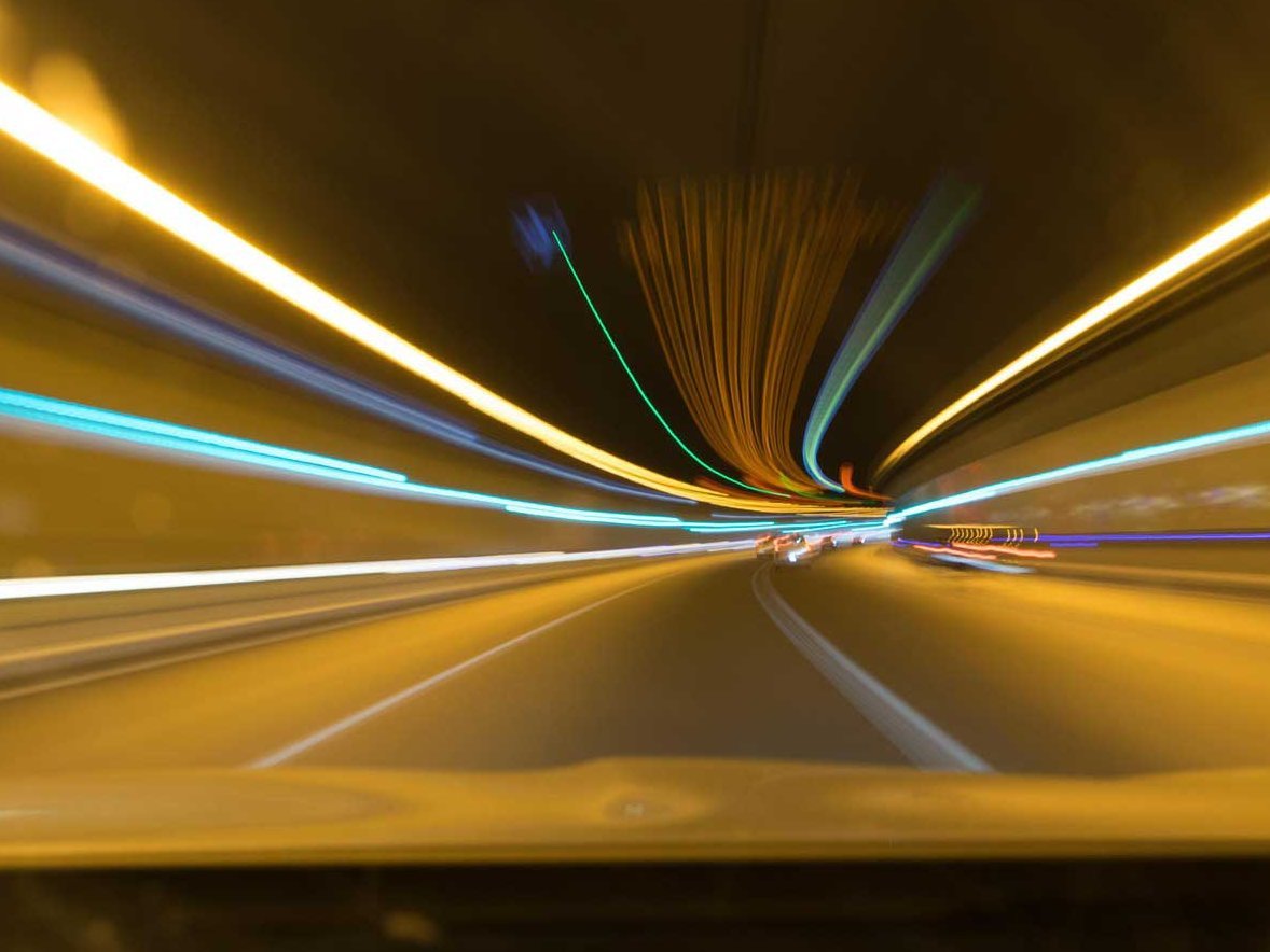 In einem Tunnel sind viele Lichterlinien zu sehen.