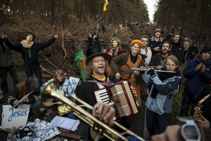 Menschen mit Schildern und Musikinstrumenten