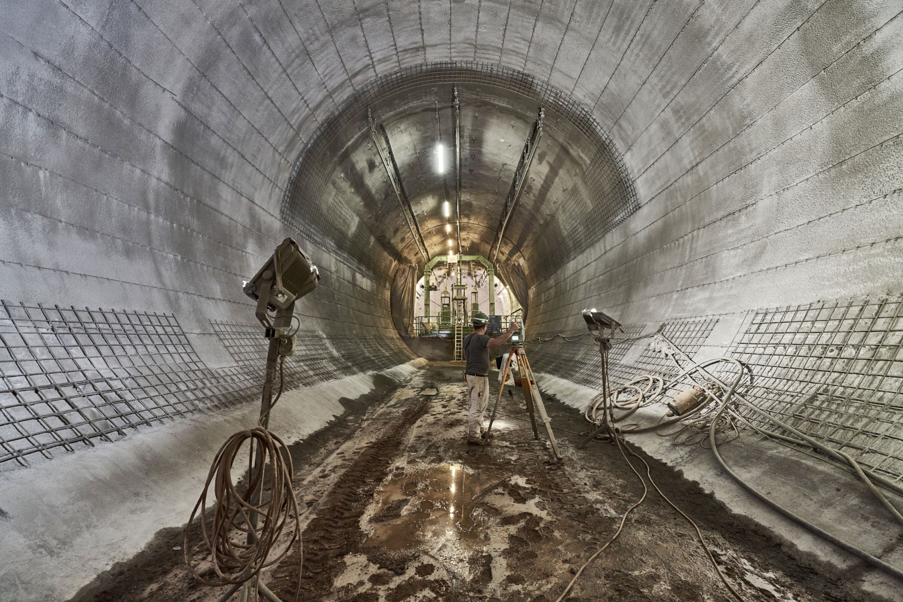 Ein Bergmann steht in einem unterirdischen Tunnel neben einem Messgerat