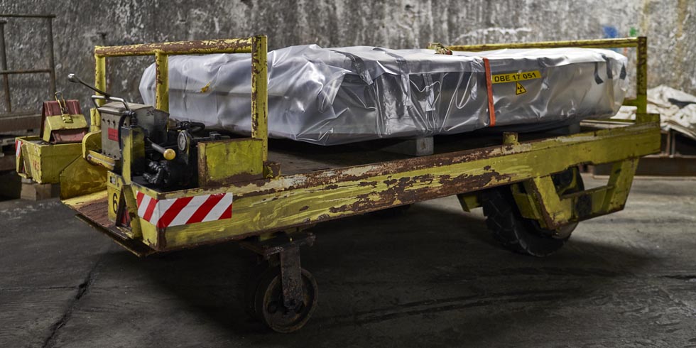 Teile eines zerschnittenen Großcontainers liegentransportfertig auf einem Schienenfahrzeug.